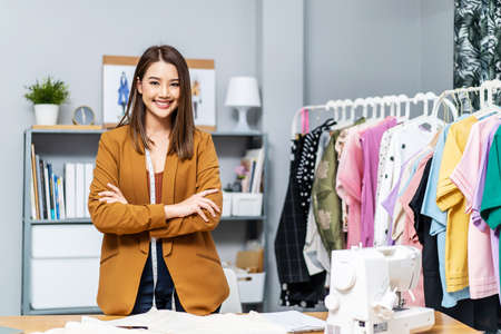 Beautiful asian woman business owner, Fashion designer standing and smile in cross arm gestures during working at fashion studio, Concept Professional Dressmaker designerの写真素材