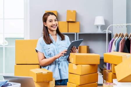 Young female owner startup received orders from clients and selling, Woman happy with box at home prepare parcel delivery in sme supply chain, procurement, omnichannel ecommerce online concept.の写真素材