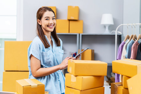Young female owner startup received orders from clients and selling, Woman happy with box at home prepare parcel delivery in sme supply chain, procurement, omnichannel ecommerce online concept.の写真素材
