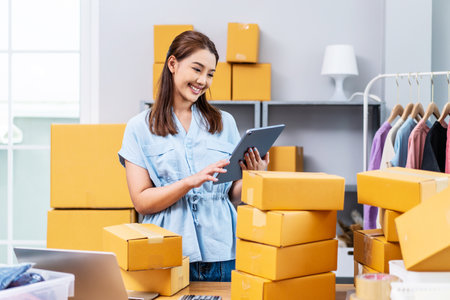 Young female owner startup received orders from clients and selling, Woman happy with box at home prepare parcel delivery in sme supply chain, procurement, omnichannel ecommerce online concept.の写真素材
