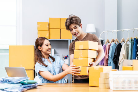 Young Asian couple business working in simple house office look like doing startup business and check store order by laptop, Surprise of couple success on making big sale of his online store.の写真素材
