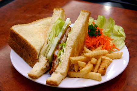 Grilled chicken sandwiches with fries and shredded carrot garnishingの写真素材