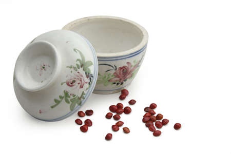 Traditional Chinese covered top soup bowl with spread of red seed.の写真素材