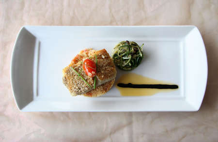 Grilled fish on top of couscous with a side of salad