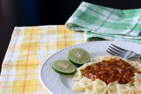A plate of bow tie pasta with zesty onion and spice gravyの写真素材