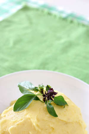 Mash potato with basil heaped up and smoothed off in a white ceramic bowlの写真素材