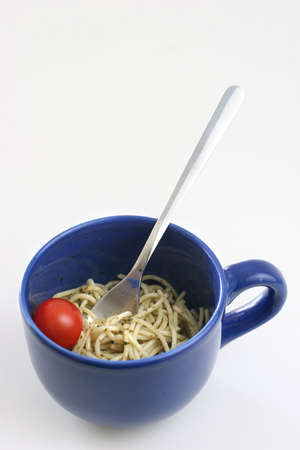 Pasta olio with a cherry tomato in a large blue ceramic cupの写真素材