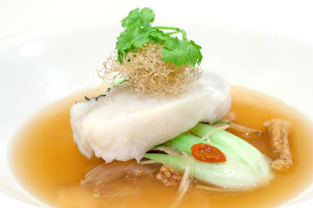 Steamed fillet of cod on a bed of vegetables in wolf berry sauce, topped with shredded fried ginger...