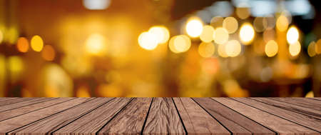 old vintage brown wood tabletop with blurred restaurant bar cafe light color background for promote and advertise product on displayの写真素材