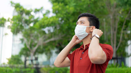 close up asian man wearing protective face mask at park outdoor to protect coronavirus and pollution...