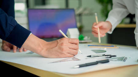 close up group of architect employee collaborating to sketch and drawing about buildings project at...