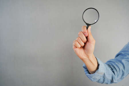 close up man hand hold magnify glass for searching information or business marketing concept