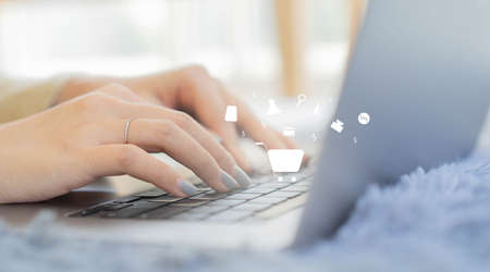 close up woman hand typing on keyboard laptop to choose and buy beauty product from marketplace...