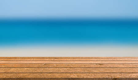 abstract blur beautiful caribbean sea ocean with wood table top plank for ads banner,show,promote on displayの写真素材