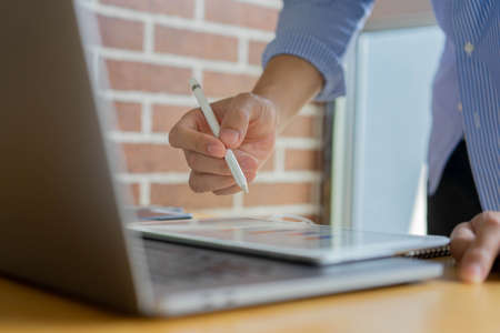 close up businessman accountant using stylus pen to explain the planning strategy and profit at home office with dashboard on tablet screen for data management of business financial and economyの写真素材