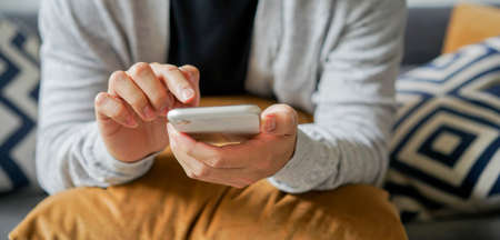 close up man hand hold mobile cell phone device and to communication video call with other for new...