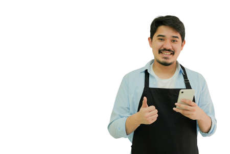 adult middle eastern business owner man smile and thumb up while hold smartphone for show or...