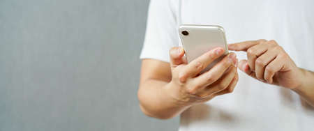 close up man hand hold mobile cell phone device for surf the internet or check news or play social...