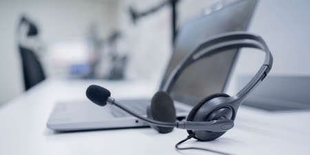 close up focus headphone call centre hotline at computer office help desk for background conceptの写真素材