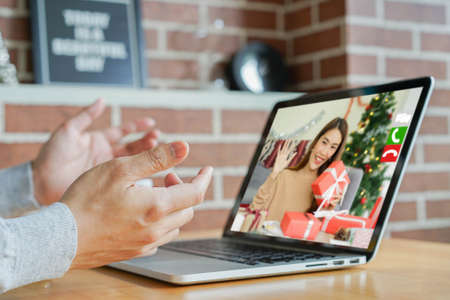close up man using video call to talking and greeting with girlfriends in ornamental living room at home for christmas celebration and people technology conceptの写真素材