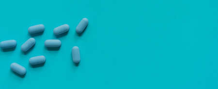 Blue pills on blue background. Top view. Copy space. Banner.の写真素材