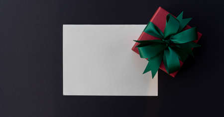 close up top view on blank white paper with christmas gift box on blank color background for design as greeting card, cyber Monday and blank friday promotional marketing ads conceptの写真素材