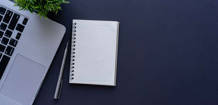 close up top view on blank notebook with pen and laptop on black table background copyspace for...