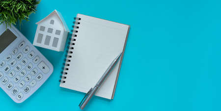close up top view group of home model ,notebook and calculator over blue color background with space for money management ,home loan and personal financial conceptの写真素材