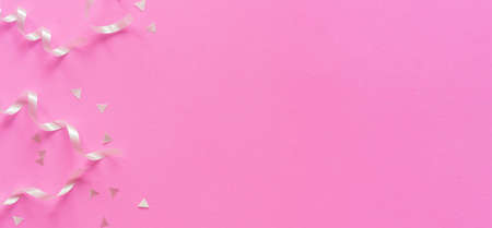 silver color of rolling ribbon and confetti on pink background with copy space celebration design conceptの写真素材