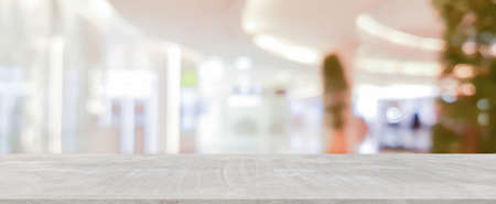 Empty white wooden table and blurred background of shopping mall. For product displayの写真素材