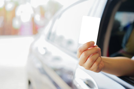 Woman hand showing blank business card on the car door, closeupの写真素材