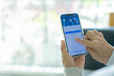 Female hands holding a smartphone with social network application on the screen.