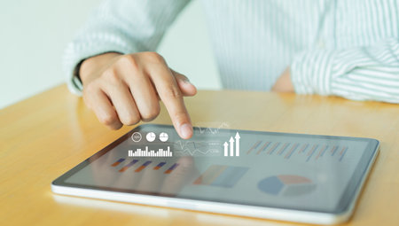 Businessman working with tablet computer and graph information diagram on wooden desk as concept
