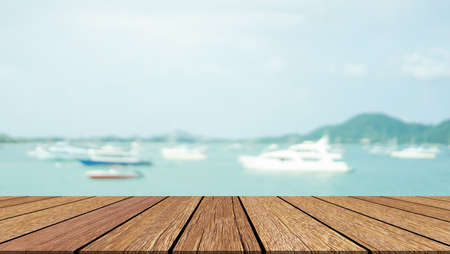 Wood table top on blur background of sea and boat - can be used for display or montage your products