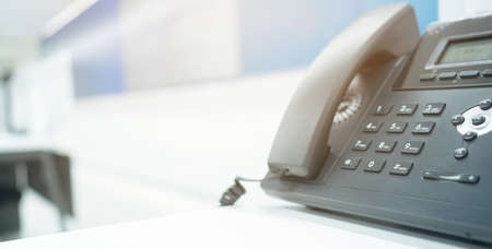 Close-up of telephone handset on desk in office. Selective focus.