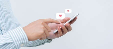 Close-up of female hands using smartphone with social media icons on white background