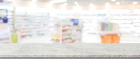 Empty top of natural stone table and blurred supermarket with bokeh light background. For product displayの写真素材