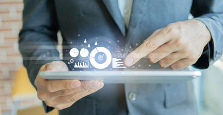 Businessman using digital tablet with financial graph and chart, business concept