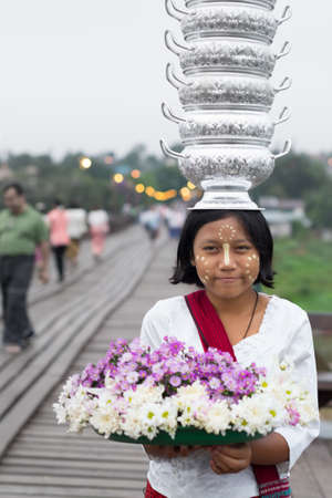 Sangkhla Buri, Kanchanaburi, Thailand - May 10, 2017 : Little Mon people with flower tray put on the head on the wooden bridge or Mon Bridge.のeditorial素材