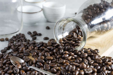 Jar of coffee bean pouring into a stone table.の写真素材