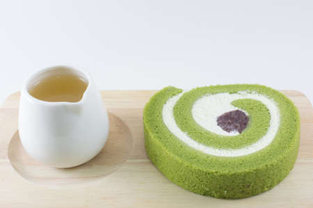 Green tea roll cake on wooden board.の写真素材