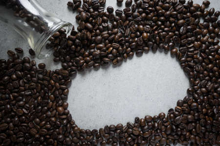 Jar of coffee bean pouring a stone table.の写真素材