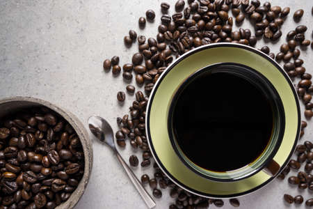 Brown cup of coffee with coffee bean on a stone table.の写真素材