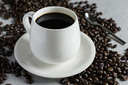 White glass of coffee with coffee bean on a stone table.の写真素材