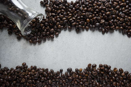 Jar of coffee bean pouring a stone table.の写真素材