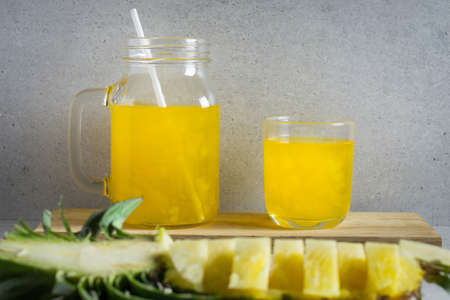 Pineapple juice in a jar and glass on stone table.の写真素材