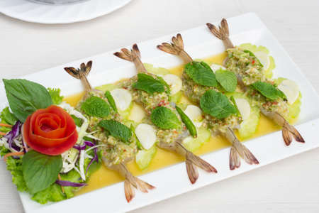 Shrimp in fish sauce with cabbage sliced in white dish on table.の写真素材