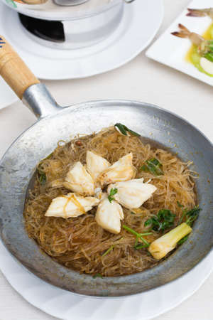 Crab with vermicelli in stainless bowl on the table.の写真素材