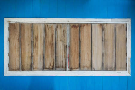 Wooden window classic on blue wall.の写真素材