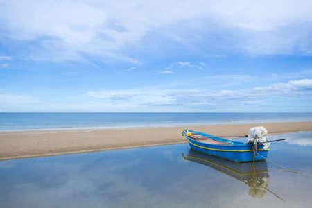 Fishing boat at sunshine on the beach with sky background.の写真素材